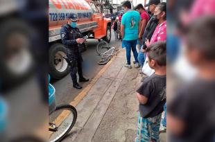 El muchacho salió de su bicicleta y aterrizó en el asfalto, quedando debajo de la pesada unidad.
