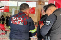 Elementos de la Policía Estatal resguardan la sucursal bancaria y aseguran la zona tras el asalto con falsa amenaza explosiva