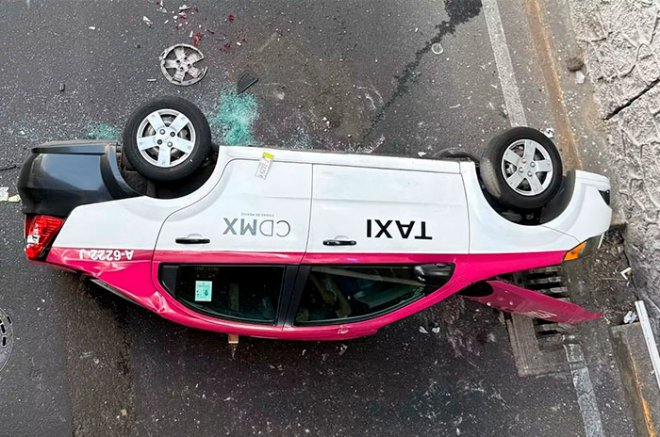 El taxi cayó desde un puente del Periférico Norte y terminó volcado sobre los carriles centrales de la vialidad, en Naucalpan.