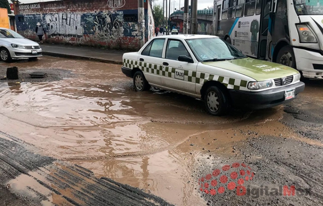 &quot;Ahogan&quot; baches la calle frente a escuela preparatoria en Toluca