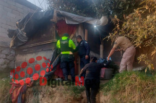 El hallazgo se registró la tarde del domingo, cuando la víctima fue encontrada boca abajo, entre ropa y junto a la cama donde presuntamente descansaba.
