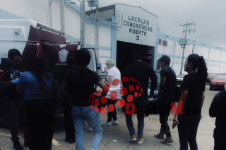 Elementos de seguridad y peritos realizan el levantamiento del cuerpo en la Central de Abasto