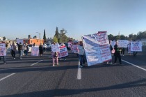 El grupo porta mantas en las que demandan la intervención de la gobernadora Delfina Gómez y de la presidenta de México, Claudia Sheinbaum.