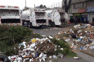 Los cinco camiones recolectores del área de Servicios Públicos con los que impiden el paso en la Vía Morelos, a la altura de Xalostoc, fueron descargados sobre el pavimento.