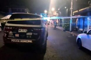 Policías resguardan la zona donde un hombre fue asesinado.
