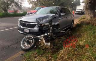 La motocicleta quedó prensada en la defensa delantera de un coche color gris