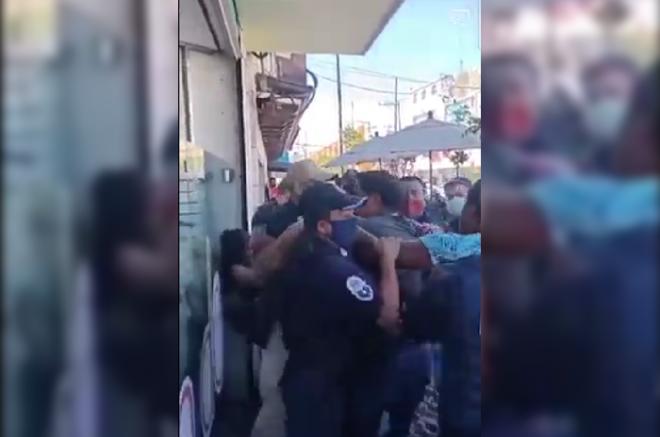 El momento fue captado en video, en cuyas imágenes se aprecia cómo unos elementos de seguridad lanzan golpes a civiles y viceversa.