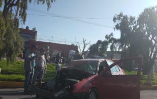Un vehículo Volkswagen tipo Jetta, color rojo, se impactó contra la parte trasera de un camión de redilas que al parecer salía de una bodega.