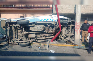 Tras perder el control, la combi terminó volcada y posteriormente se proyectó contra la fachada de una vivienda y un poste de luz.